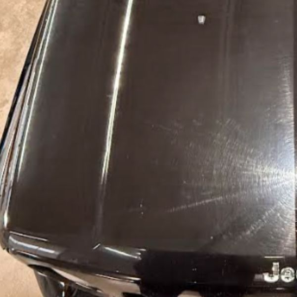 Polished black vehicle hood after detailing